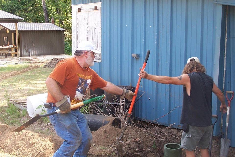 Members digging and clearing behind the range building