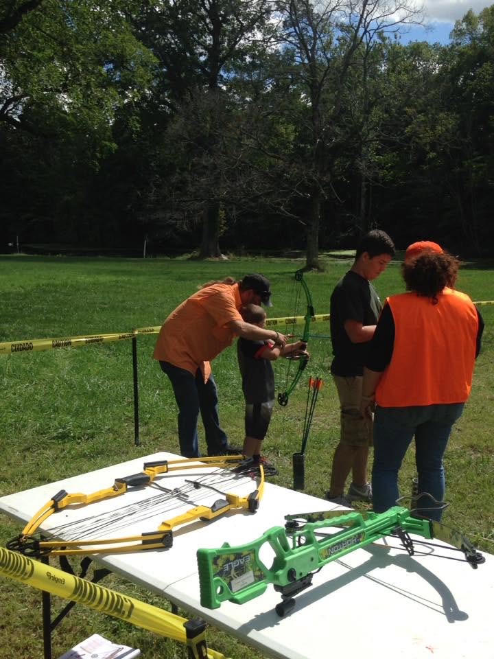 A youth learning archery with an instructor at the club